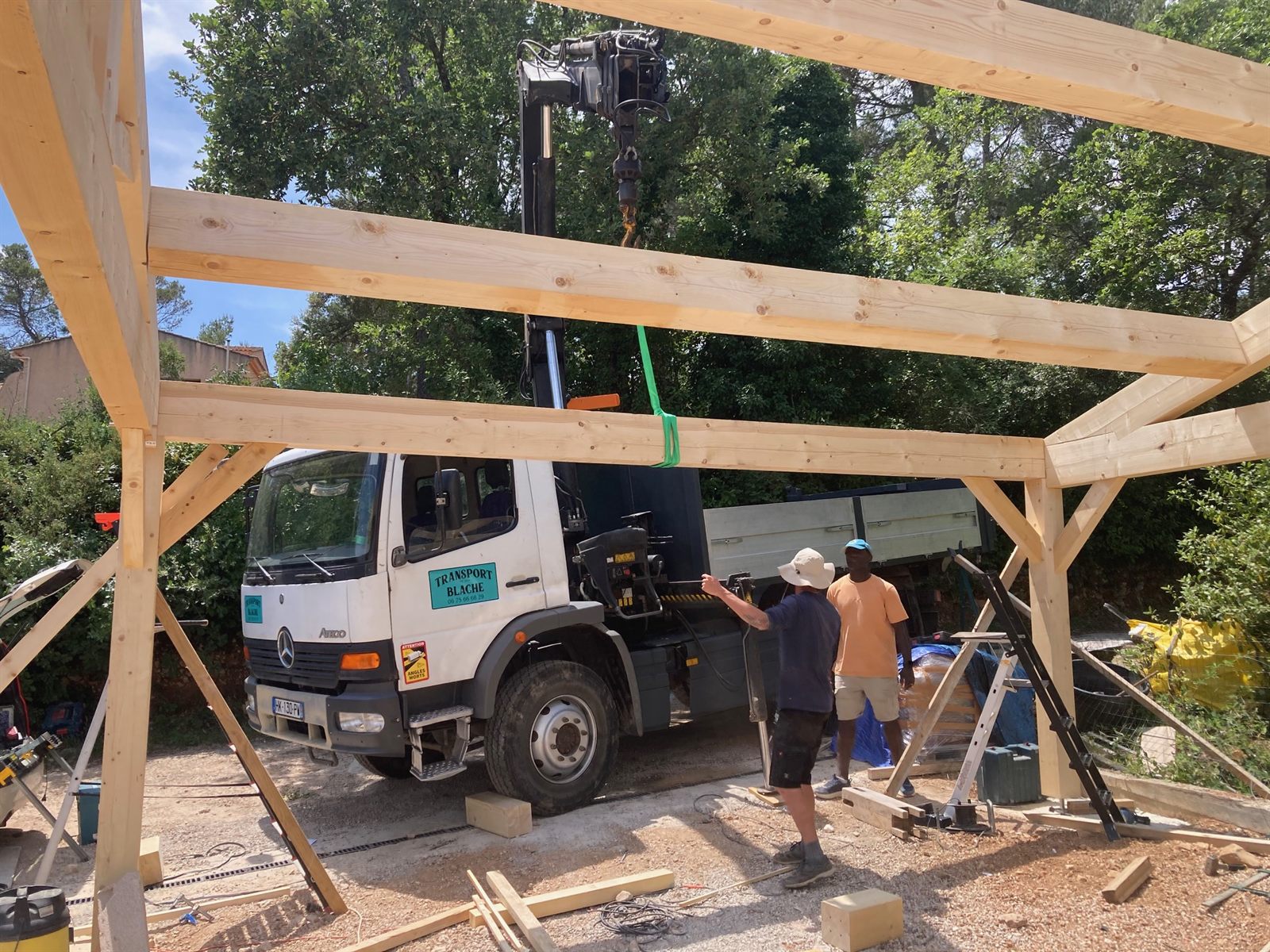 Montage d'une charpente assisté par le camion grue Transport Blache dans le Var